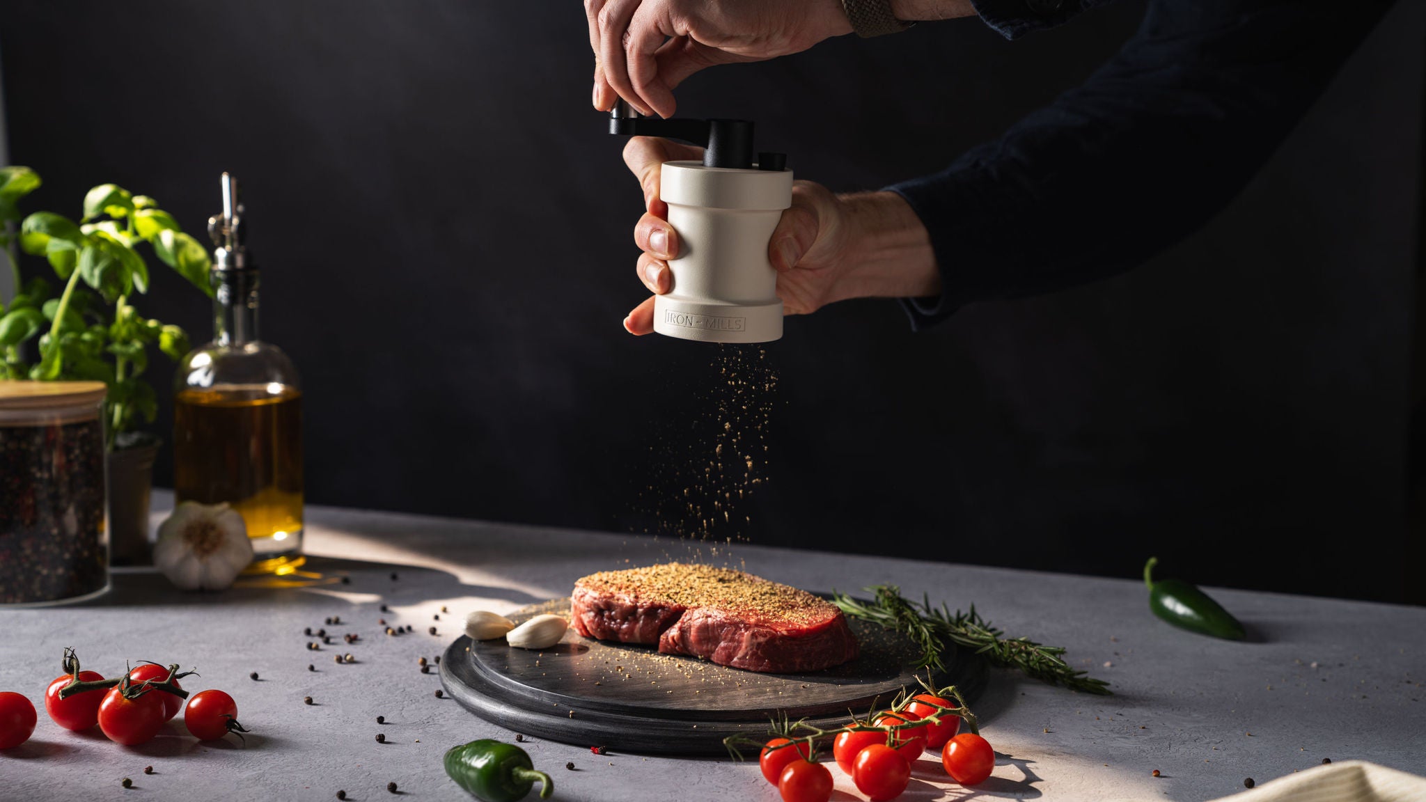 Oyster White Cast Iron Pepper Mill Grinding Fresh Pepper Corns onto Juicy Steak