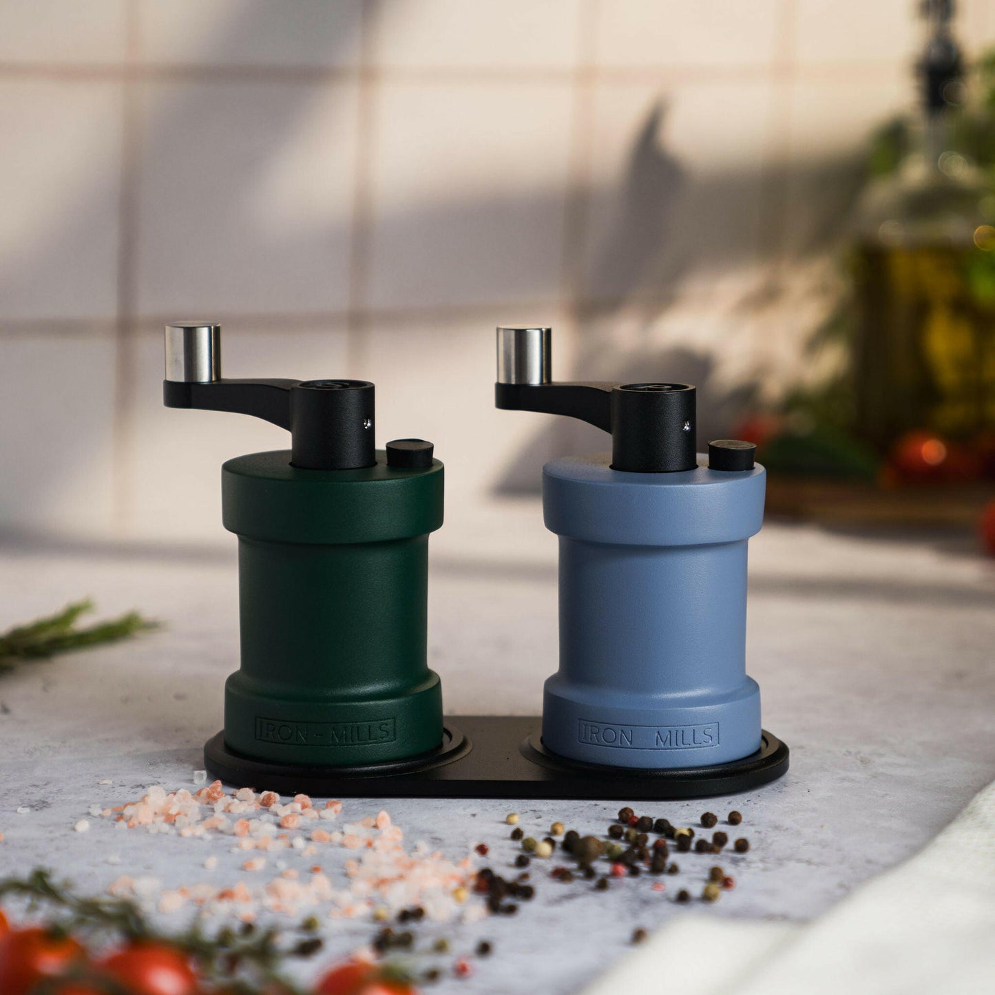 Iron-Mills ivy green and pigeon blue salt and pepper mills set on a durable oak base, creating a unique pairing for the table