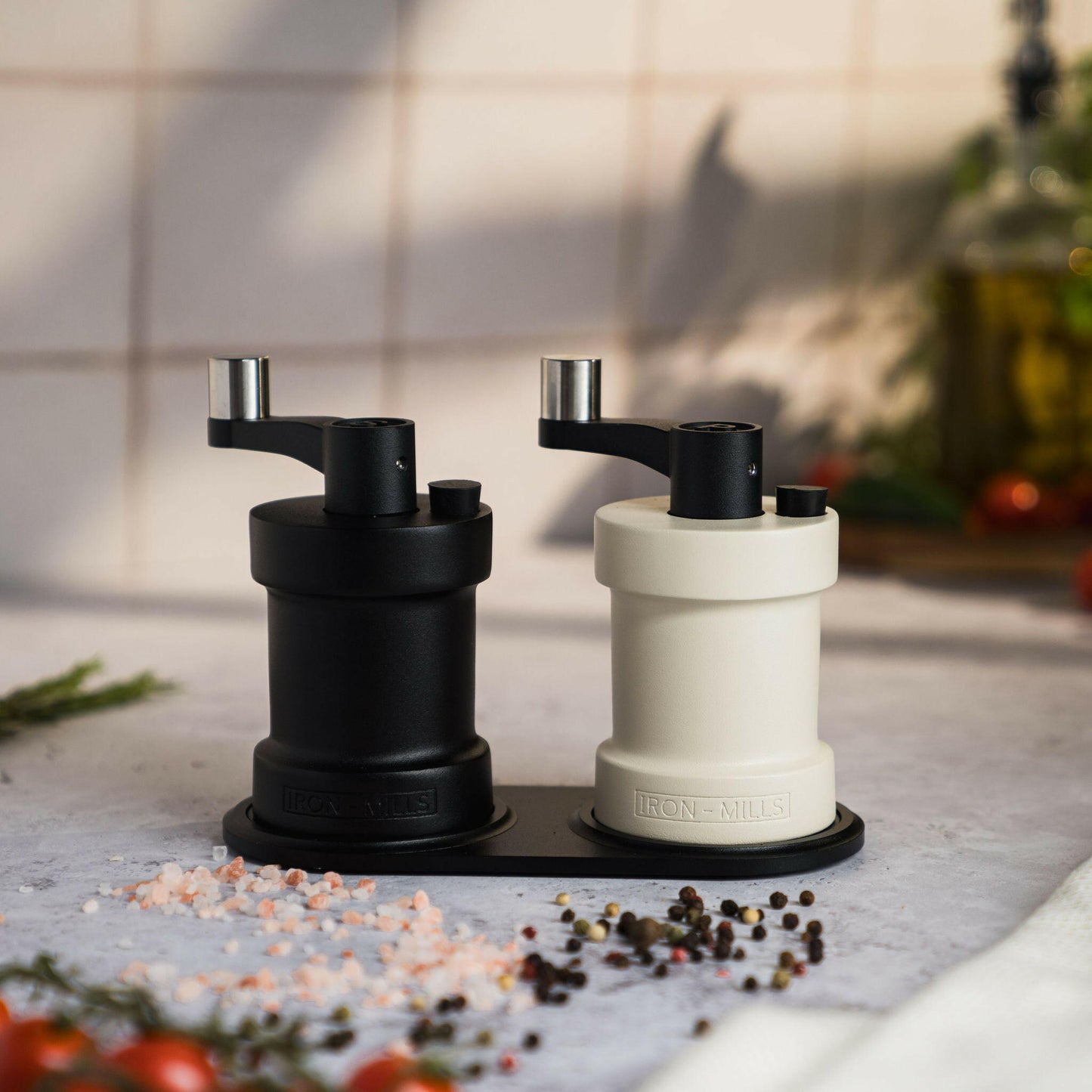 Iron-Mills onyx black and oyster white salt and pepper mills displayed on a mill rest.